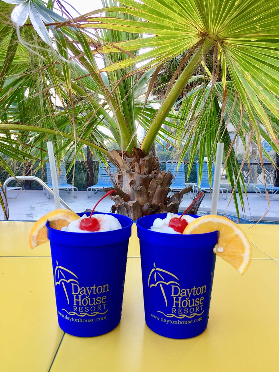 Two drinks sitting next to each other on the beach