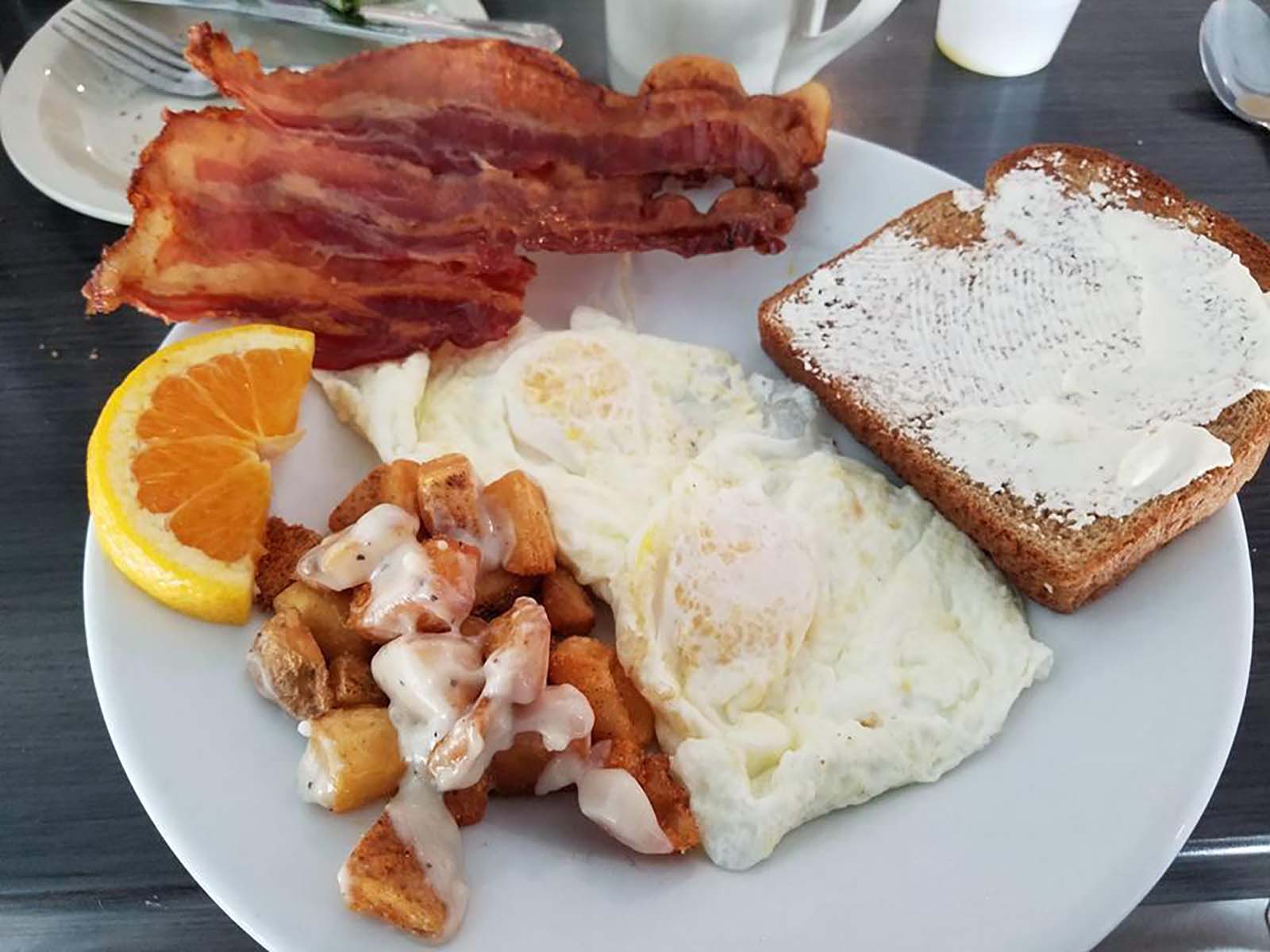 Backon, Orange, Eggs, & Hash browns on a plate